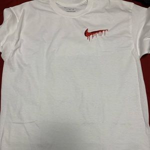This is a t-shirt with an embroidery design of a “Drippy” Nike logo on it.